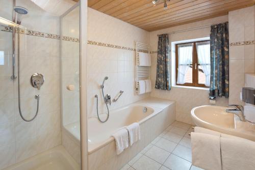 y baño con bañera, ducha y lavamanos. en Salenberghof Ferienwohnung Bergsee, en Rieden