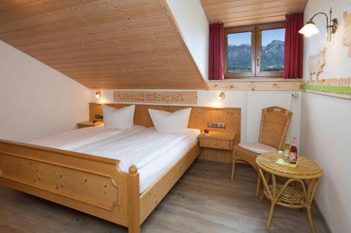 a bedroom with a bed and a table and a chair at Salenberghof Ferienwohnung Bergsee in Rieden