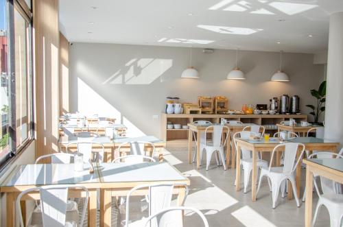 un restaurante con mesas blancas y sillas blancas en Hotel Vip´s en Mar del Plata