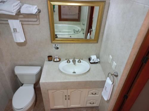 a bathroom with a sink and a toilet and a mirror at Marhialja Hotel Boutique in Oaxaca City