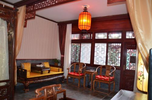 sala de estar con mesa, sillas y lámpara en Qianmen Courtyard Hotel en Pekín