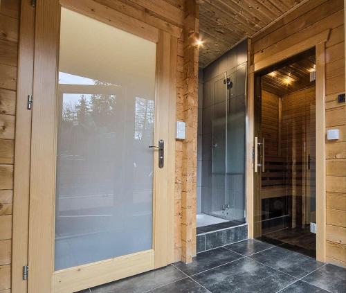 d'une porte vitrée donnant sur une salle de bains pourvue d'une douche. dans l'établissement VisitZakopane - Coral Spa Apartment, à Zakopane