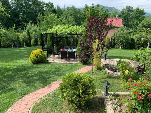 a garden with a table in a gazebo at Villa Gagula in Sarajevo