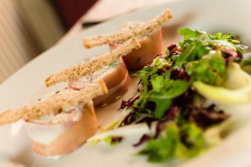a white plate with a sandwich and a salad at Hotel Stefaner in Tires