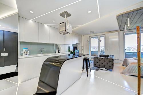 a kitchen and living room with white cabinets at Central Apartments by Bed&Bath in Kraków