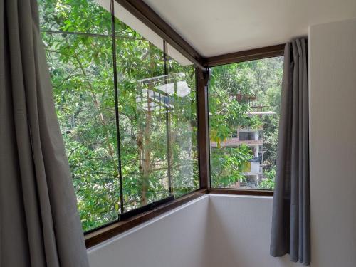 a room with a large window with trees at Supertramp Hostel Machupicchu in Machu Picchu