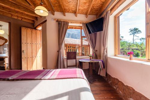 a bedroom with a bed and a window at Unuwasi Hotel & Villa in Calca