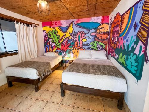 - 2 lits dans une chambre ornée d'une peinture murale dans l'établissement Supertramp Hostel Machupicchu, à Machu Picchu