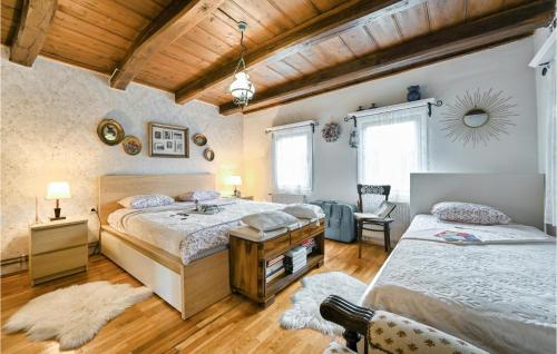 Kupljenovo的住宿－Cozy Home In Kupljenovo With Heated Swimming Pool，一间卧室配有两张床、一张桌子和一把椅子
