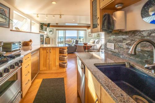 a kitchen with a large sink and a living room at Puffin's Perch in Fort Bragg