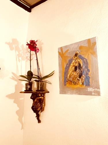 a wall with a picture and a plant on a wall at Casa les bambous in Nîmes