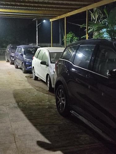 a row of parked cars in a parking lot at night at Gruham Malpe Homestay Udupi in Malpe