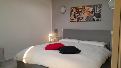 Schlafzimmer mit einem weißen Bett und einem roten Kissen in der Unterkunft La Romanina in Bagnone