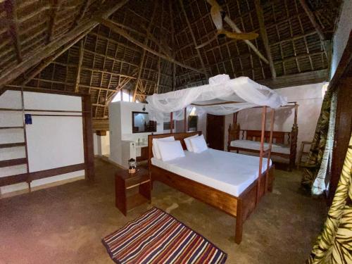 a bedroom with a bed with a canopy at Zuzanu house in Nungwi