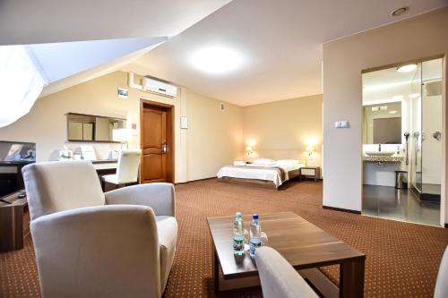 une chambre d'hôtel avec un lit et un salon dans l'établissement Leśny Dwór, à Radom