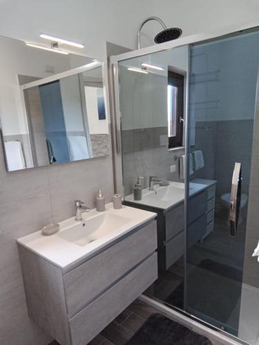 a bathroom with two sinks and a shower at The sunset in San Teodoro