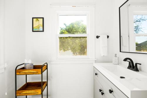 a white bathroom with a sink and a window at Mid-Town Escape in Ventura