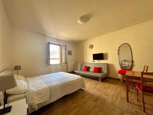 sypialnia z łóżkiem, stołem i lustrem w obiekcie Apartment Nel Centro Della Citta w mieście Pistoia
