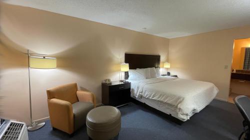 una habitación de hotel con una cama y una silla en Slumber Inn Harrisonville, en Harrisonville