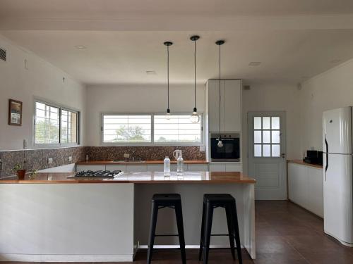 a kitchen with a large island with two bar stools at Quinta al sur - Quinta con pileta en Paraná in Paraná