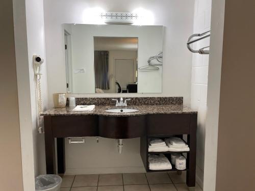 a bathroom with a sink and a mirror at Slumber Inn Harrisonville in Harrisonville