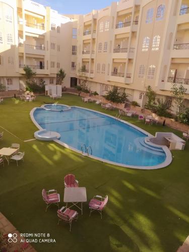 an overhead view of a large swimming pool with chairs and tables at New Sunset Resort in Aswan