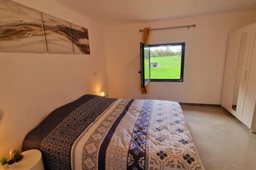 1 dormitorio con cama y ventana en Gîte de charme dans la campagne de Montauban, en Montauban