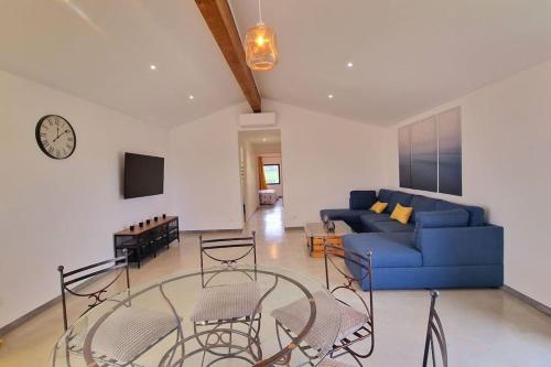 sala de estar con sofá azul y sillas en Gîte de charme dans la campagne de Montauban, en Montauban