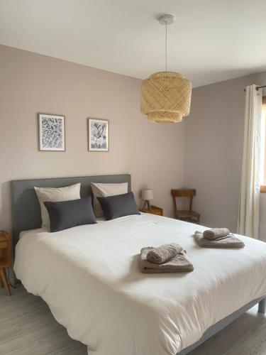 a bedroom with a large white bed with towels on it at Appartement au centre de St Martin de Belleville in Saint-Martin-de-Belleville