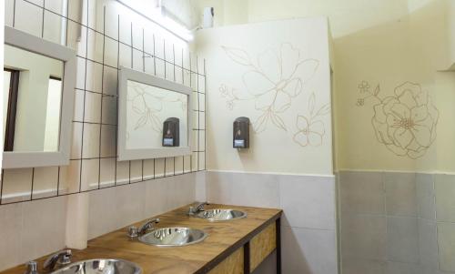 Baño con 2 lavabos y espejo en HOSTEL PUNTO RAMIREZ en Salta