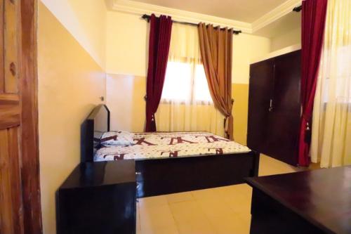 una piccola camera con letto e finestra di Villa Nika a Lomé