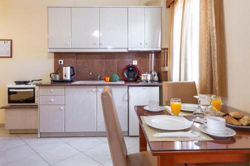 a kitchen with a wooden table and a table and chairs at Irida Beach Resort Suites in Kyparissia
