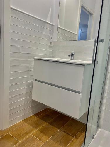 a white bathroom with a sink and a mirror at Estudio a 400 metros Ribera FREE PARKING in Córdoba