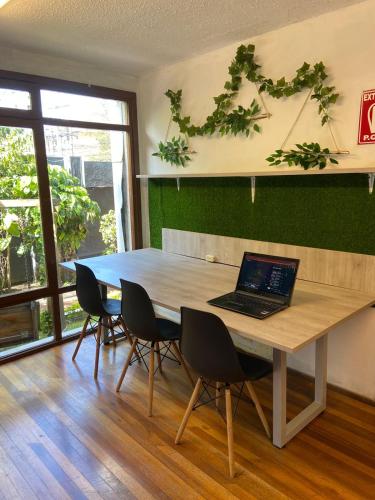 a laptop sitting on a table in a room with chairs at Blue house La Floresta in Quito