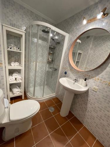 uma casa de banho com um chuveiro, um WC e um lavatório. em Apartamentos Los Cubos de Llanes 1 em Llanes