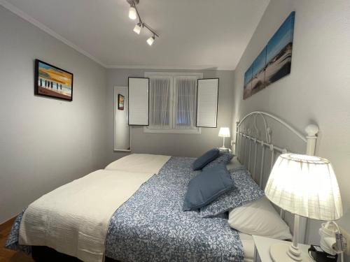 Un dormitorio con una cama con almohadas azules. en Apartamentos Los Cubos de Llanes 1 en Llanes