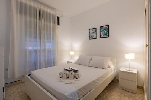 a white bedroom with a bed with two candles on it at El Bajondillo Beach a 30 metros de la playa in Torremolinos