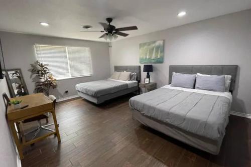 a bedroom with two beds and a ceiling fan at Convenient Home Near Airport in Fort Worth