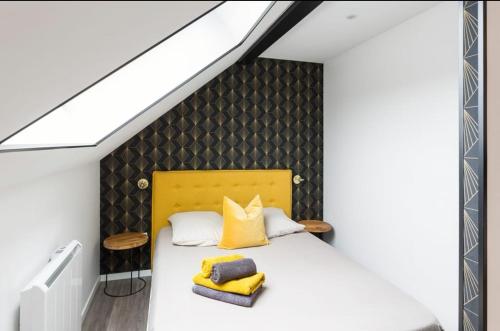 ランスにあるBienvenue à Reims type studio charmant et lumineux 2eme étageのベッドルーム1室(黄色のヘッドボード付きのベッド1台付)