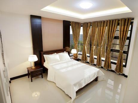 a bedroom with a white bed and a window at tagaytay transient ph in Tagaytay