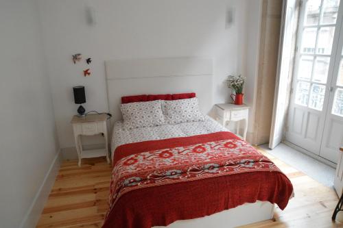 una camera da letto bianca con un letto con una coperta rossa di Oporto Almada 329 a Porto