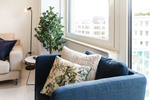 a blue couch with a pillow in a living room at Hamilius Apartments City Center Luxembourg by Rentaroo in Luxembourg