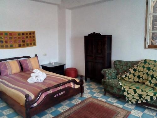 sypialnia z łóżkiem i krzesłem z pluszowym misiem w obiekcie ferme Walila w mieście Douar Doukkara