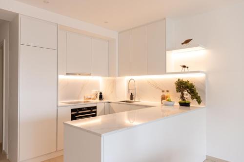 a kitchen with white cabinets and a white counter top at Hamilius Apartments City Center Luxembourg by Rentaroo in Luxembourg