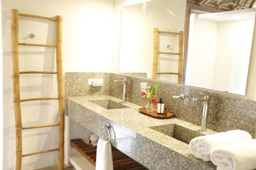 uma casa de banho com 2 lavatórios e um espelho grande em Casa Origen em Los Naranjos
