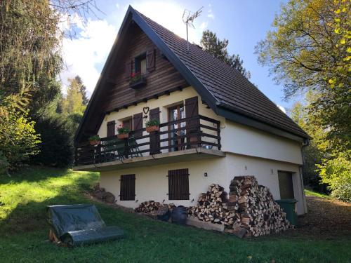 a house with a pile of fire wood in front of it at Chalet Le Cerf in Wildersbach