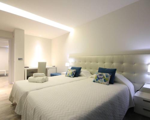 a bedroom with two beds with white sheets and blue pillows at Villa Camacho iv - Mansion House in Arco da Calheta