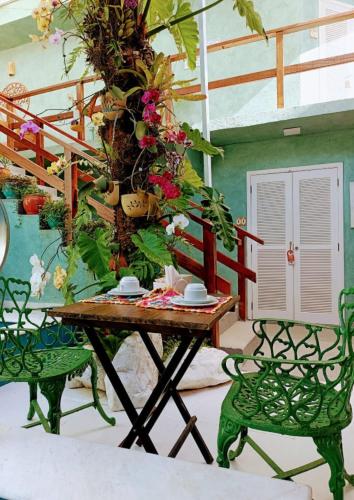 a table and chairs in a room with a plant at Pousada Tô na Praia Juquehy in Juquei