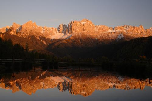 a reflection of a mountain in a body of water at Hotel Stefaner in Tires