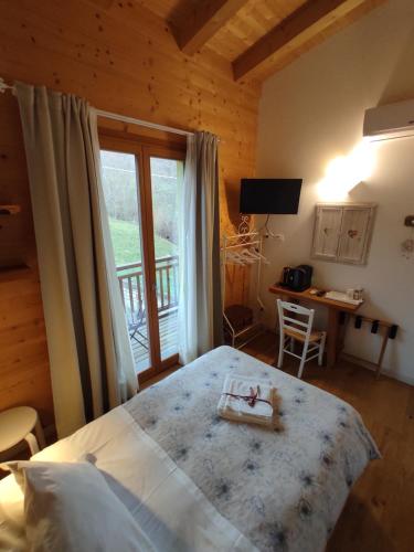 1 dormitorio con cama, escritorio y ventana en Agriturismo La Soglia Del Parco, en Ranica